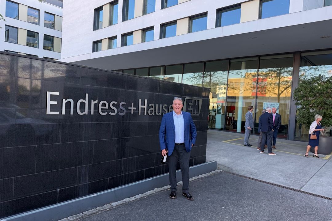 A member of the Rust team outside Endress+Hauser's offices in Reinach, Switzerland, the manufacturer's signage on the building behind him